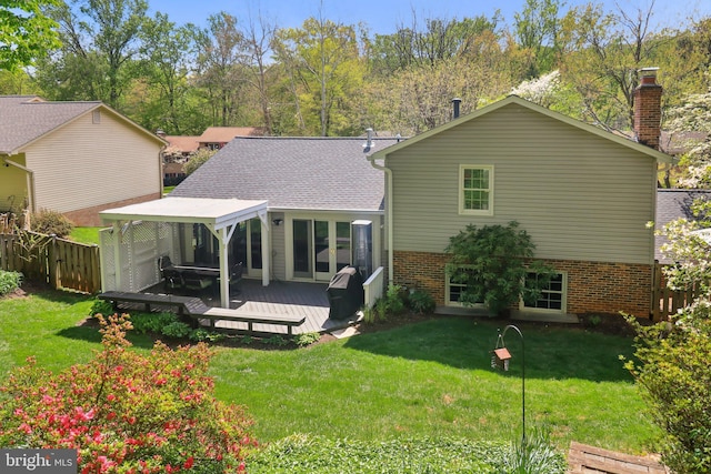 rear view of property with a lawn, a chimney, fence, and a deck