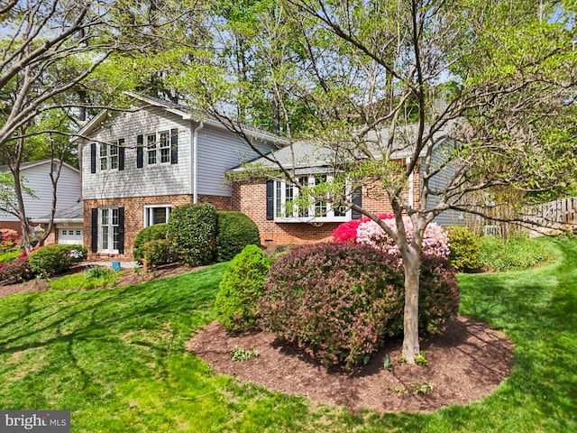 view of front facade featuring brick siding and a front yard