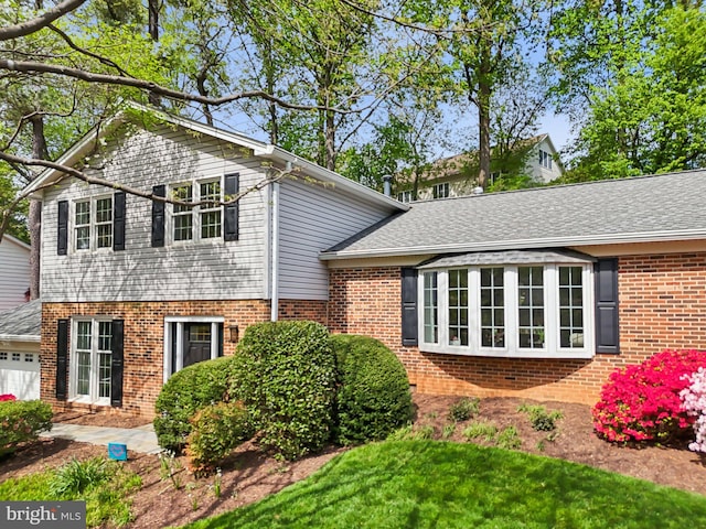 view of side of home with a shingled roof, brick siding, and a garage