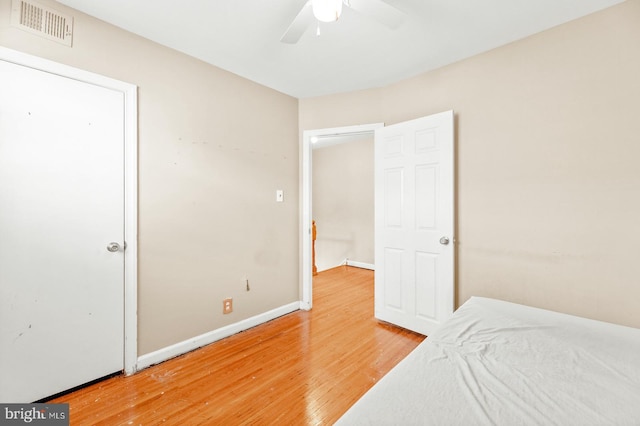 bedroom with visible vents, baseboards, light wood-style floors, and ceiling fan