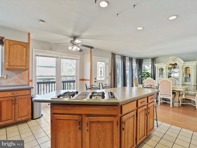 kitchen featuring stainless steel gas stovetop, light tile patterned flooring, and a healthy amount of sunlight