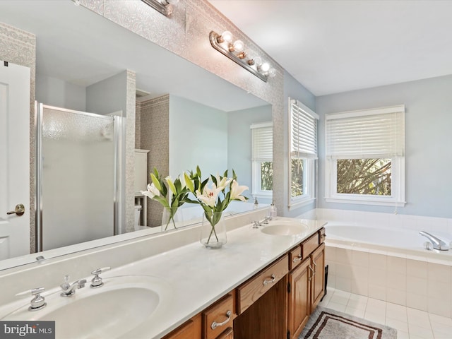 full bath featuring a bath, a shower stall, tile patterned floors, and a sink