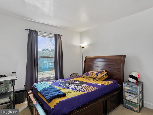 bedroom with baseboards and light carpet