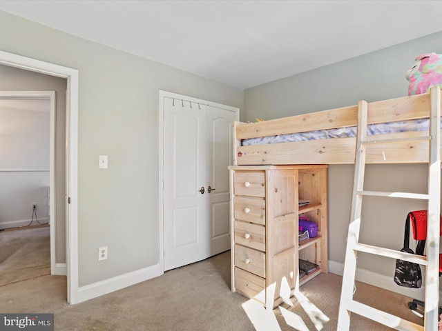 bedroom featuring a closet, baseboards, and carpet floors