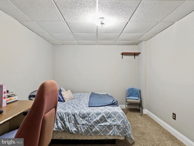 bedroom with a paneled ceiling, carpet floors, and baseboards