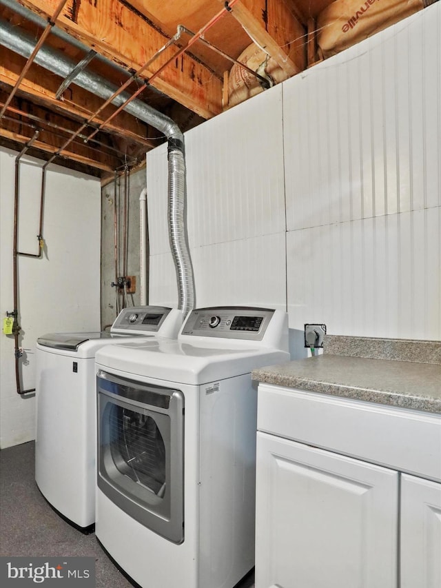 clothes washing area featuring washer and clothes dryer and cabinet space