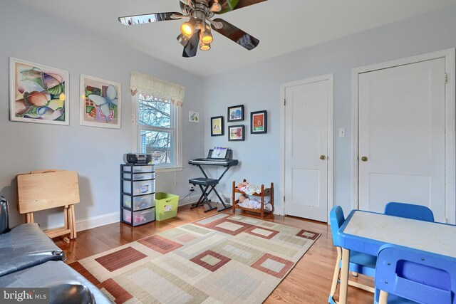 office featuring baseboards, a ceiling fan, and light wood finished floors