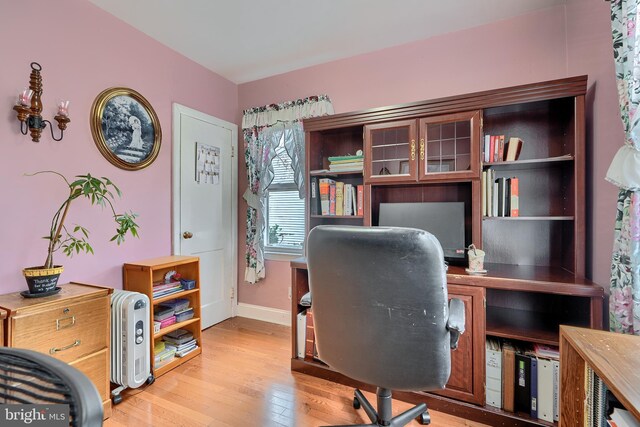 office space with baseboards and light wood-style floors