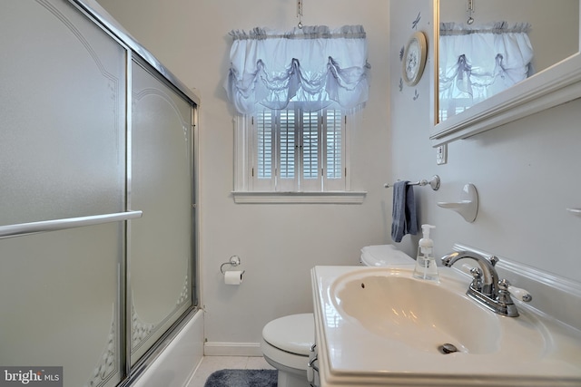 full bathroom with tile patterned flooring, toilet, bath / shower combo with glass door, and a sink