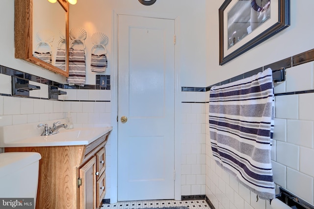 full bath with vanity, tile walls, and toilet