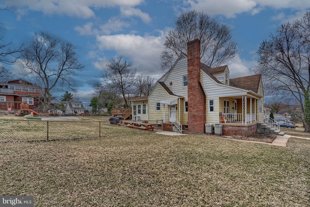 view of property exterior with a lawn, entry steps, a porch, fence, and a chimney