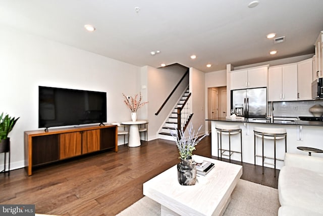 living room with stairway, recessed lighting, baseboards, and dark wood-style flooring