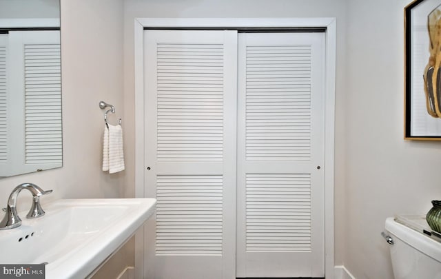 bathroom featuring a sink, a closet, and toilet