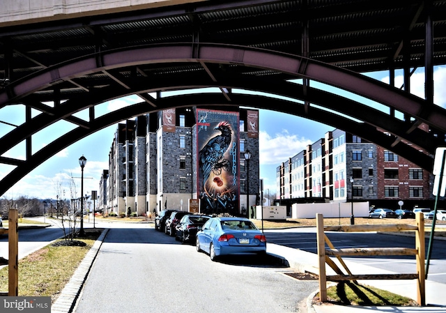 view of road with curbs, a view of city, street lights, and sidewalks