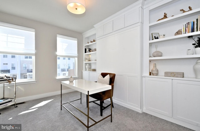 office space featuring built in features, baseboards, and light colored carpet