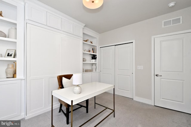 office space featuring visible vents, light carpet, and built in shelves