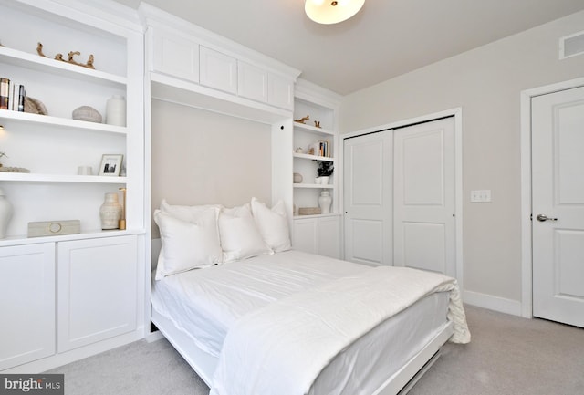 bedroom featuring a closet, light carpet, and baseboards