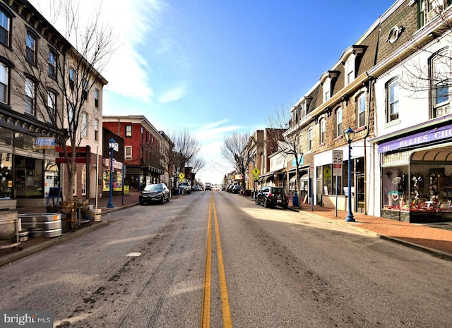 view of road featuring curbs, street lights, and sidewalks