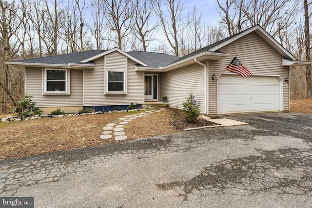 ranch-style house with driveway, a shingled roof, and a garage