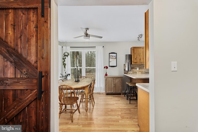 dining room featuring a ceiling fan and light wood finished floors