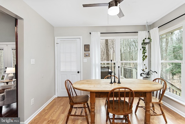 dining room featuring light wood-style flooring, baseboards, and ceiling fan