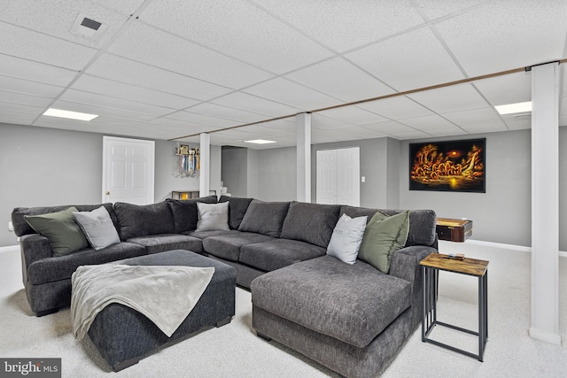 living room with visible vents, a paneled ceiling, and baseboards