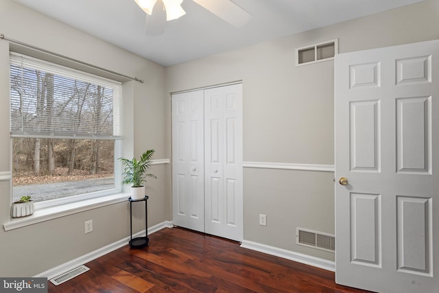 bedroom with dark wood finished floors, visible vents, and baseboards