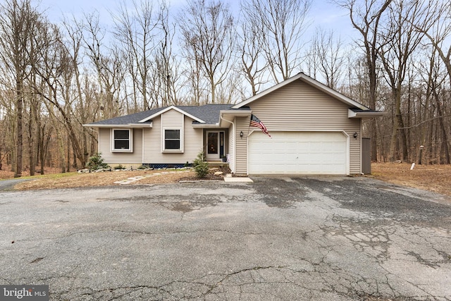 view of front facade featuring aphalt driveway, an attached garage, and roof with shingles