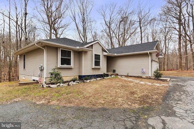 view of front of home featuring a garage, driveway, and a shingled roof