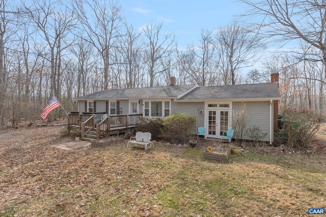 view of front of home featuring a deck, french doors, and a chimney