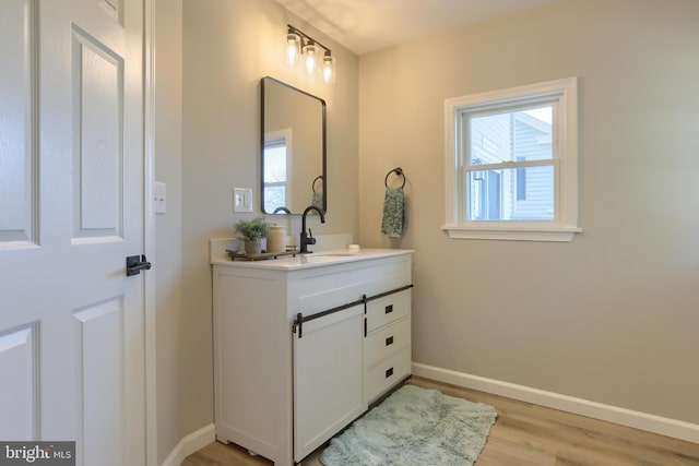 bathroom featuring a wealth of natural light, baseboards, wood finished floors, and vanity