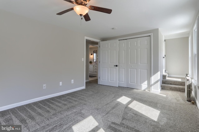 unfurnished bedroom with baseboards, carpet floors, a closet, and a ceiling fan