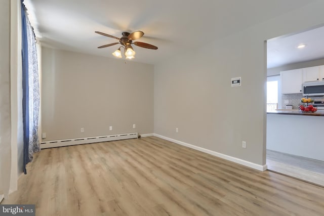 empty room featuring a ceiling fan, baseboards, light wood finished floors, and a baseboard radiator