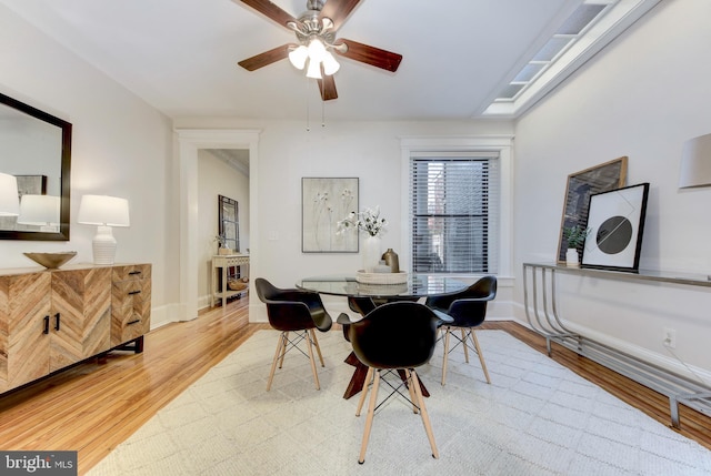 dining room featuring light wood-style floors, baseboards, and ceiling fan