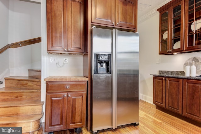 kitchen with baseboards, glass insert cabinets, stainless steel refrigerator with ice dispenser, and light wood-type flooring