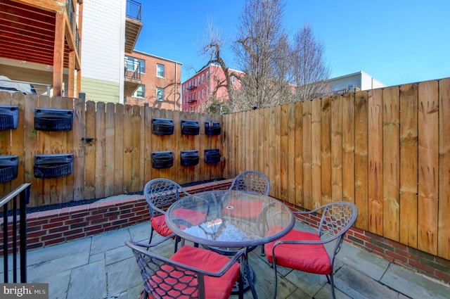 view of patio featuring outdoor dining area and fence