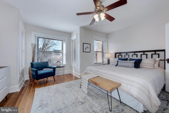 bedroom with a ceiling fan, baseboards, and hardwood / wood-style flooring