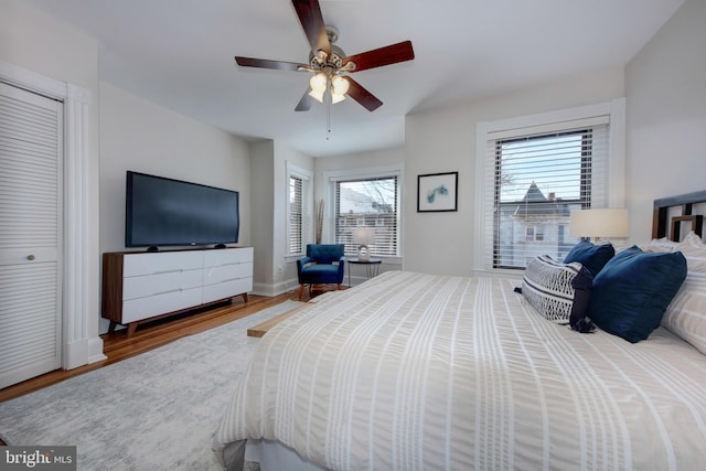 bedroom featuring wood finished floors, baseboards, and ceiling fan