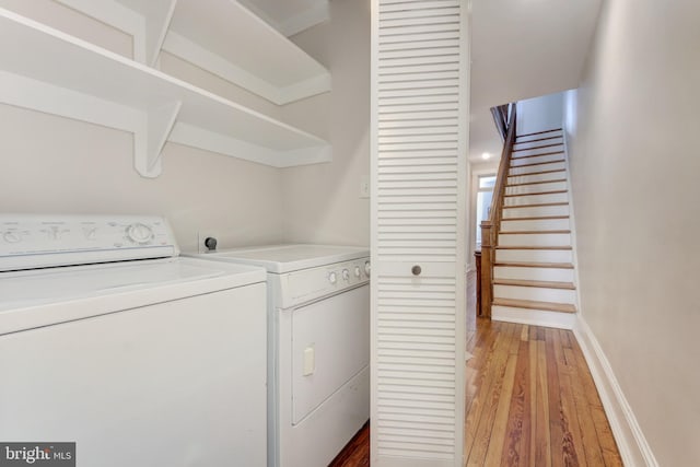 laundry room featuring laundry area, light wood-style flooring, separate washer and dryer, and baseboards