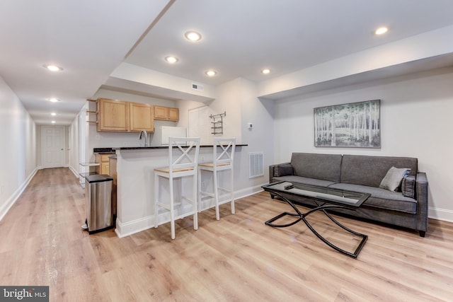 living room featuring recessed lighting, visible vents, baseboards, and light wood-style flooring