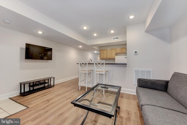 living area featuring recessed lighting, visible vents, baseboards, and light wood finished floors