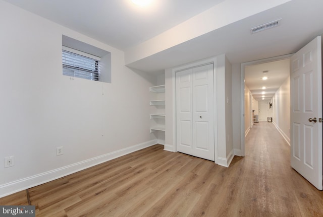 unfurnished bedroom with wood finished floors, visible vents, and baseboards