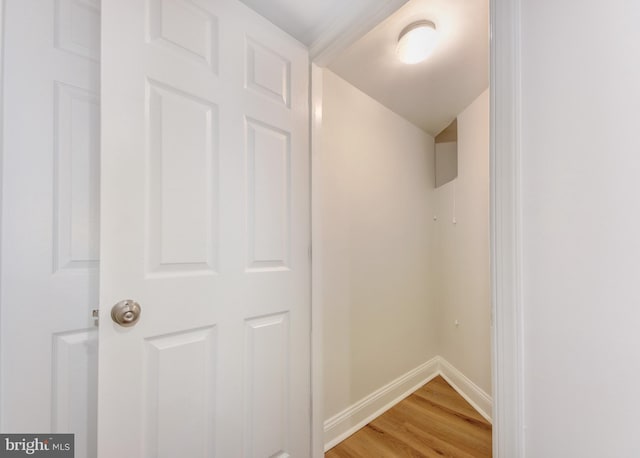 hall with light wood-type flooring and baseboards