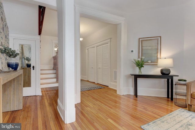 entrance foyer with stairs, light wood-style floors, visible vents, and baseboards