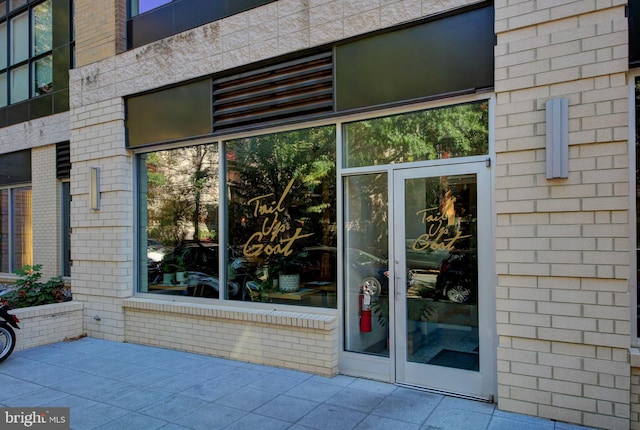 doorway to property featuring brick siding