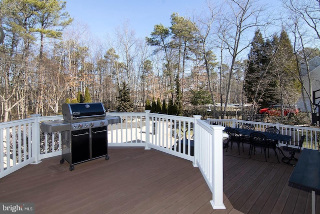 wooden terrace featuring outdoor dining space and a grill