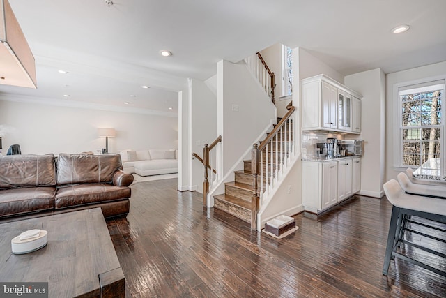 living room featuring stairway, recessed lighting, and dark wood-style flooring