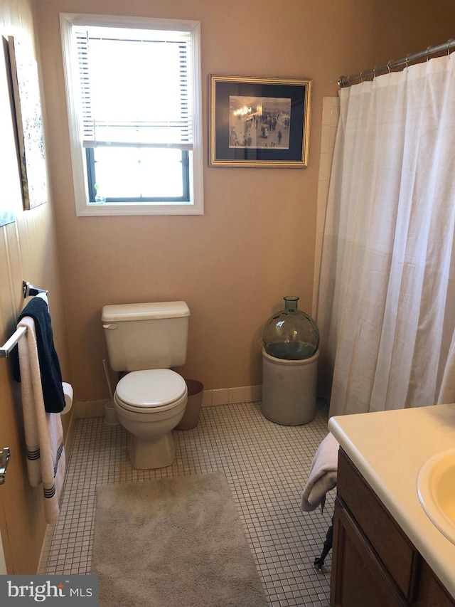 full bath with vanity, tile patterned floors, toilet, and baseboards