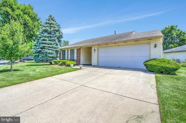 ranch-style house featuring a front lawn, an attached garage, and driveway