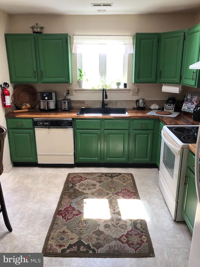 kitchen with visible vents, white range with electric cooktop, a sink, green cabinetry, and dishwasher